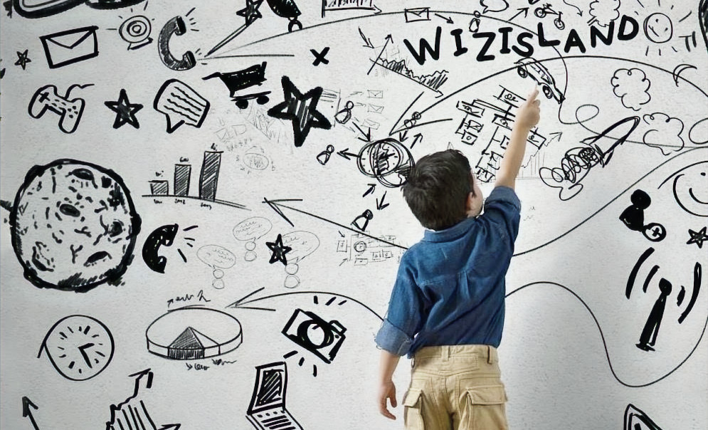 A child exploring the illustrated WizIsland discovery wall