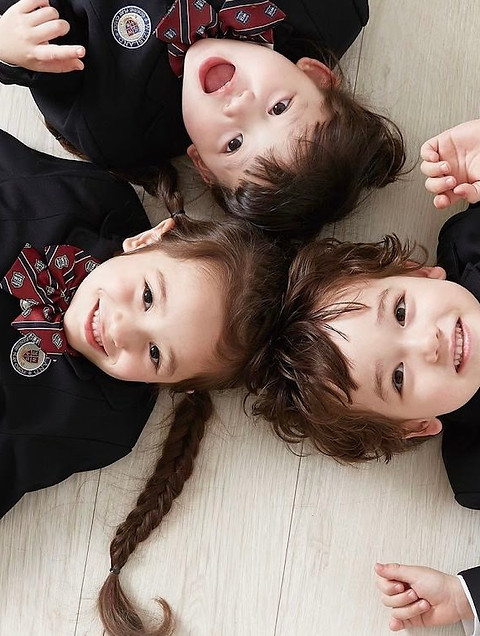 Three children sharing a playful moment at WizIsland